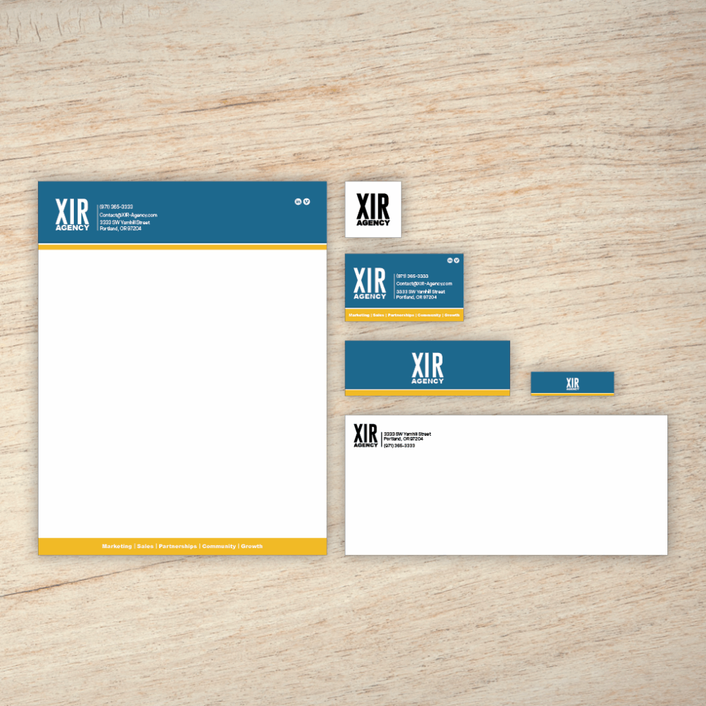 An example of the Branding Plus Package on a wood panel background; which includes a single logo design, business card design, letterhead and email header, and envelope.