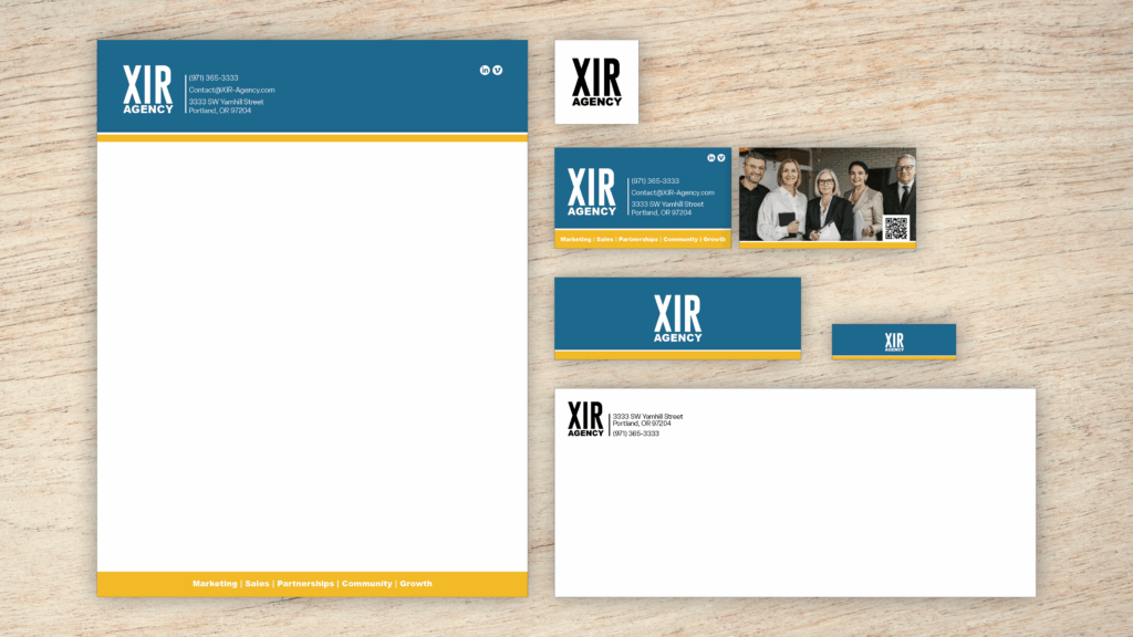 An example of the Branding Plus Package on a wood panel background; which includes a single logo design, two-sided business card design, letterhead and email header, and envelope.